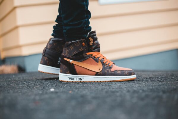 Pair of luxury collaboration sneakers featuring iconic brands, captured outdoors.