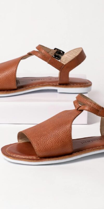 Set of elegant brown leather sandals displayed on a sleek white studio background.